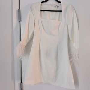 White dress, flattering fit, fun feather detail on sleeves